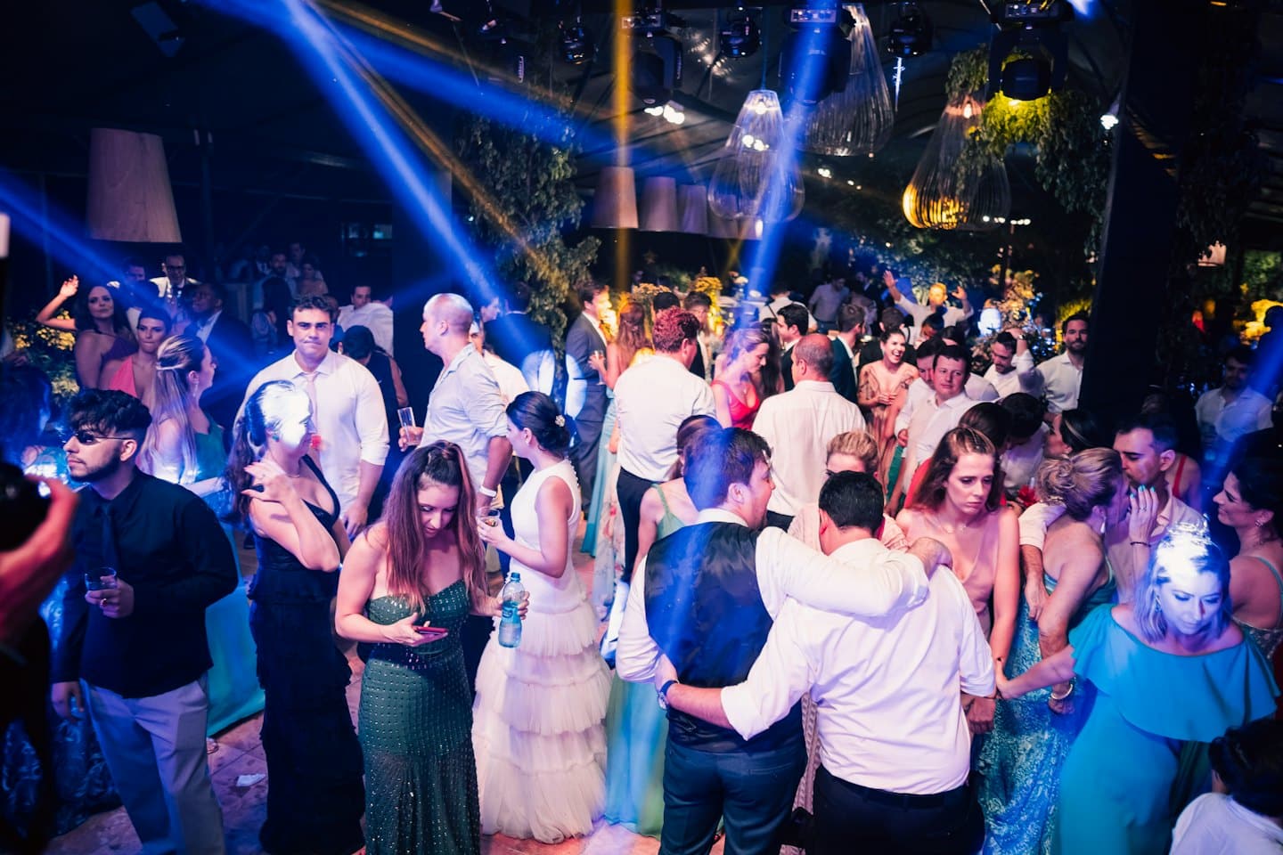A group of people dances together at an indoor event.